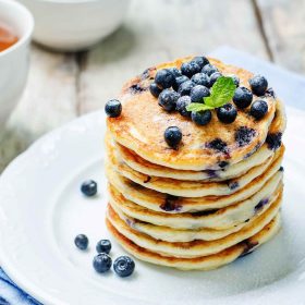 A stack of blueberry and lemon pancakes