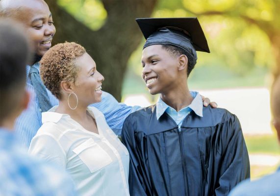 son graduating in cap and gown smiling at mom