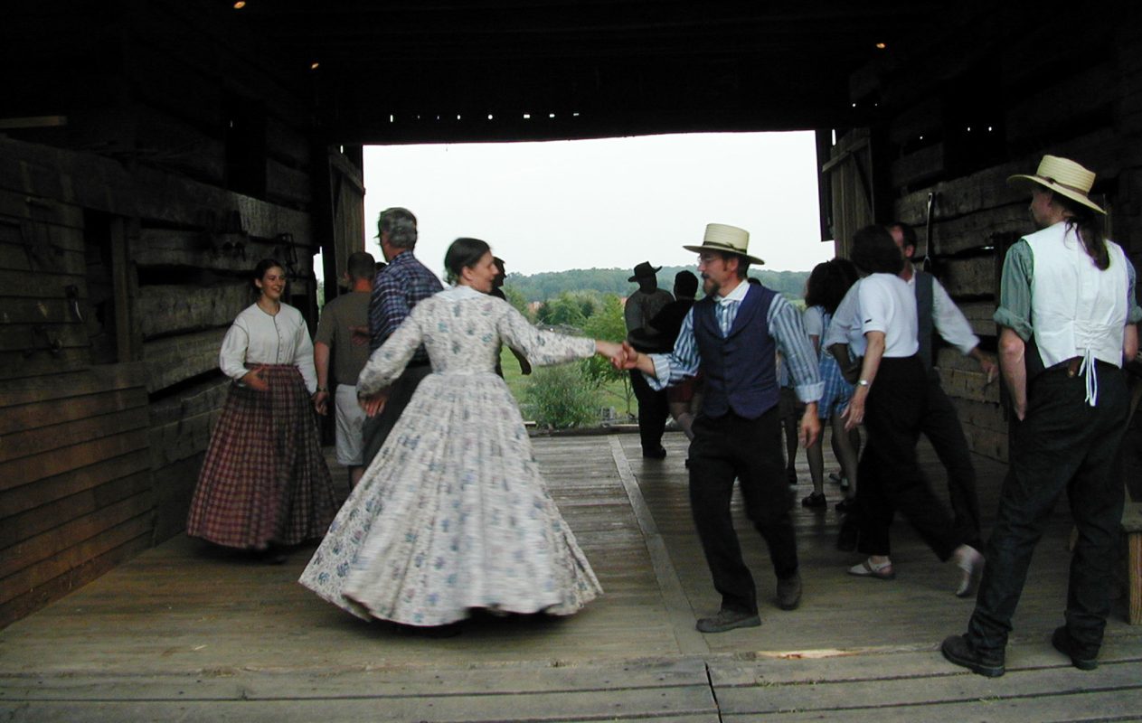 a group of people dancing in a barn