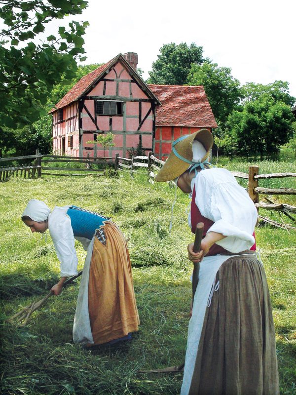 2 women raking hay at the frontier culture museum
