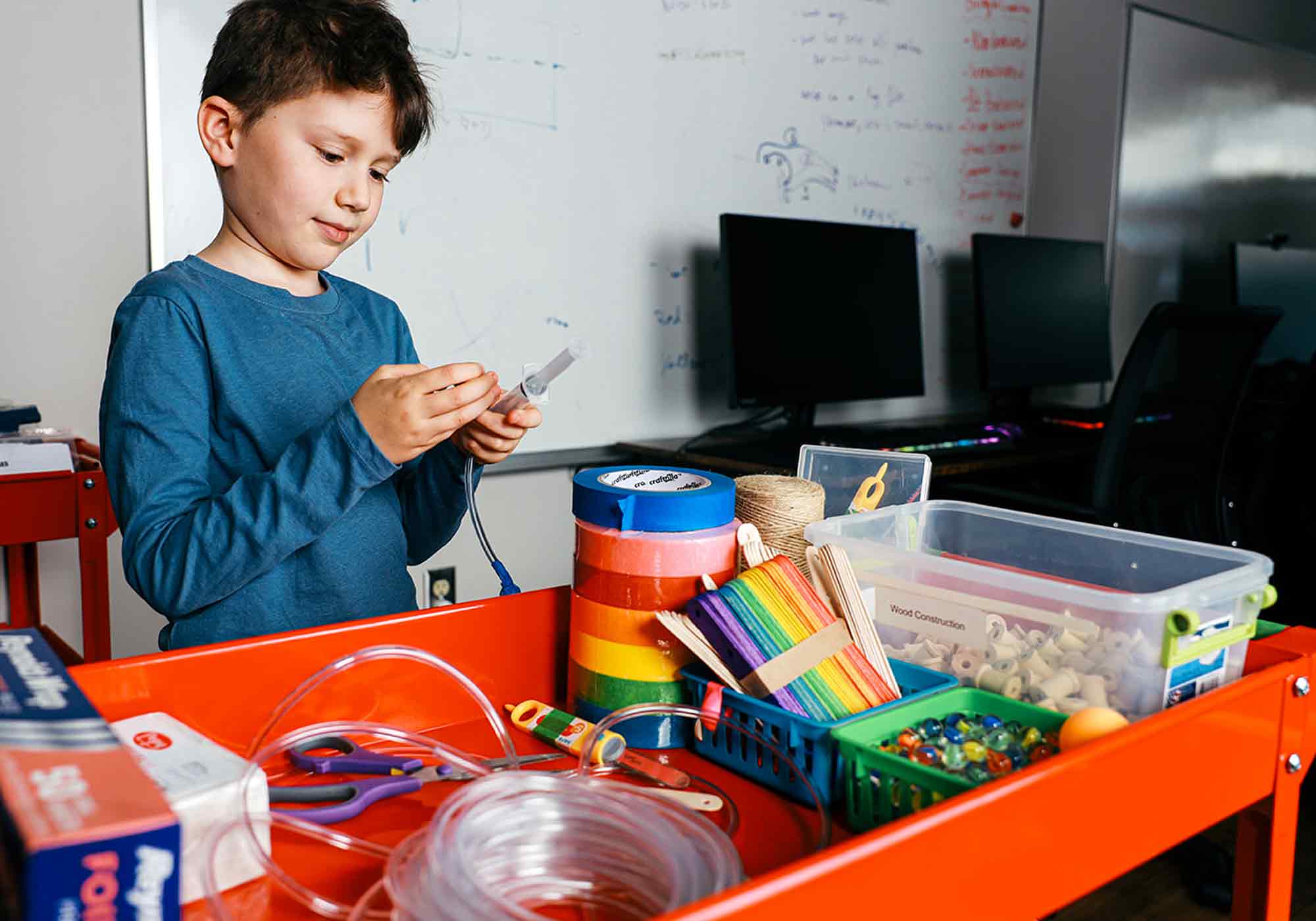 child working on science projects with lots of different materials such as legos, duct tape and foil at Blue Ridge Boost in Charlottesville