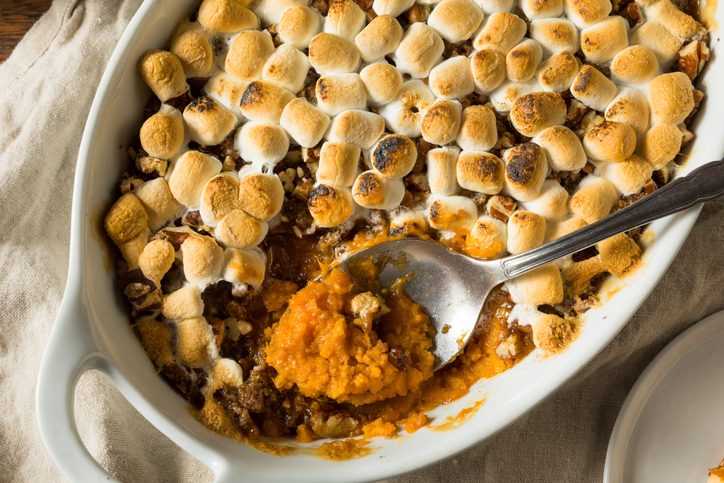 spoon scooping Homemade Sweet Potato Casserole out of ceramic dish